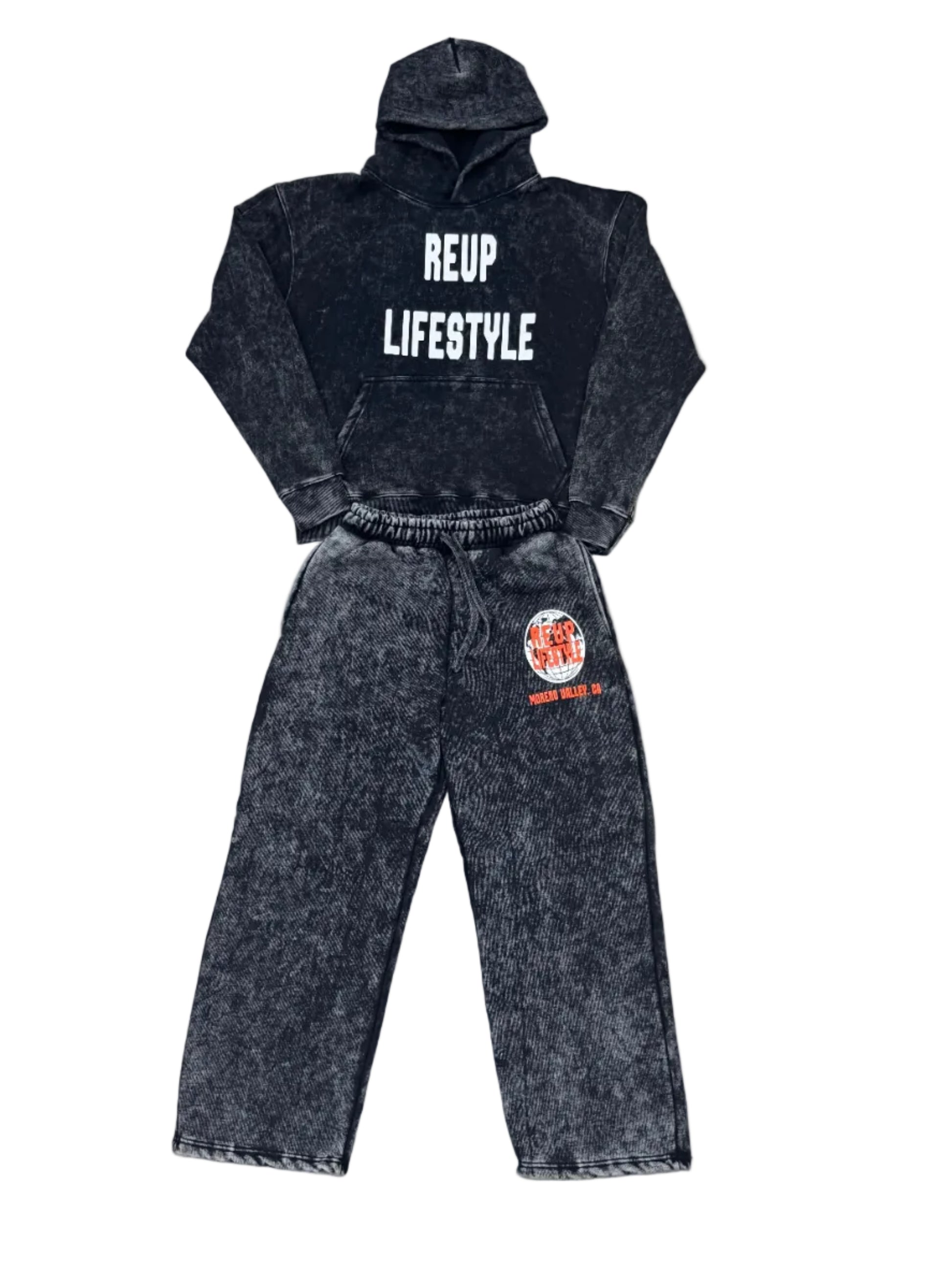 Black hoodie and jeans laid out on a concrete surface with visible branding.